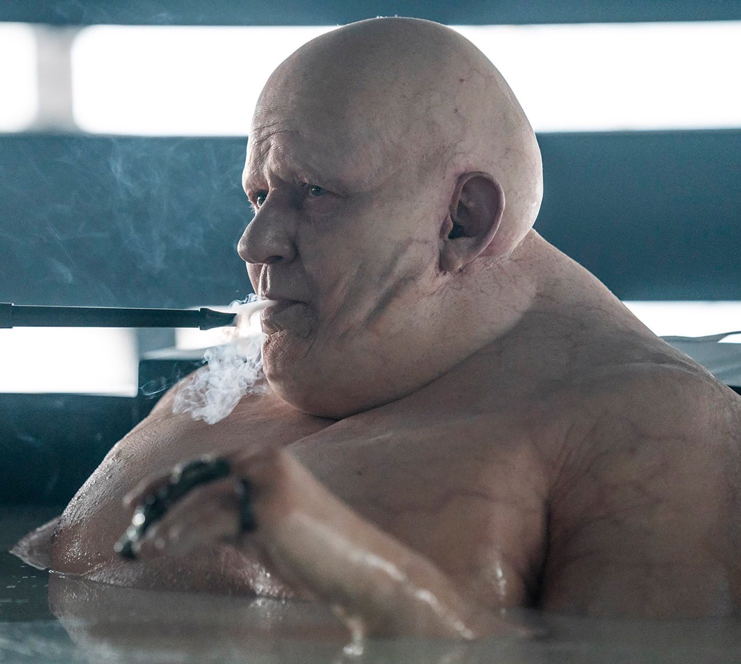 Bald, pale Baron Harkonnen from Dune sitting in a steaming bath, smoking a long black pipe.